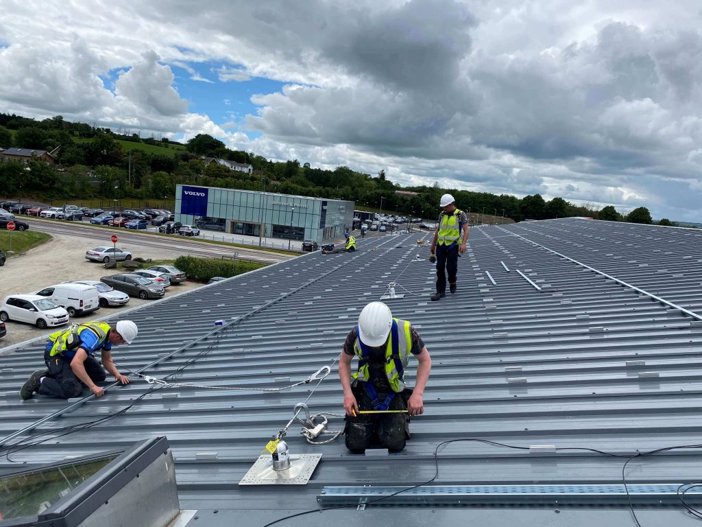Solar energy company installing solar panels on a commercial roof in Galway